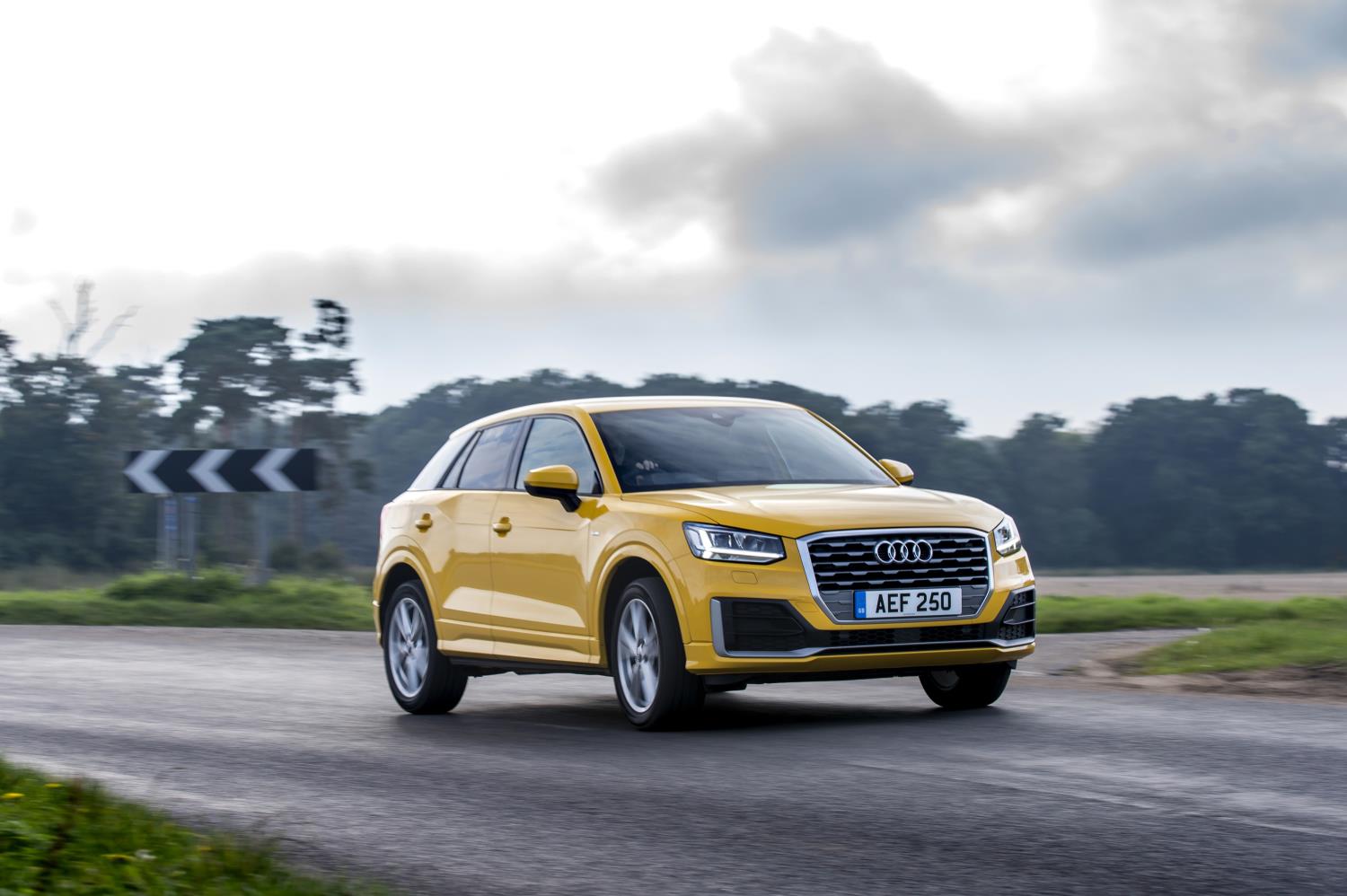 Bright yellow Audi Q2 driving down the road towards you